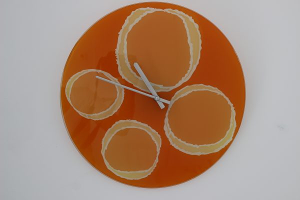 Horloge en verre au décor orange vitaminé