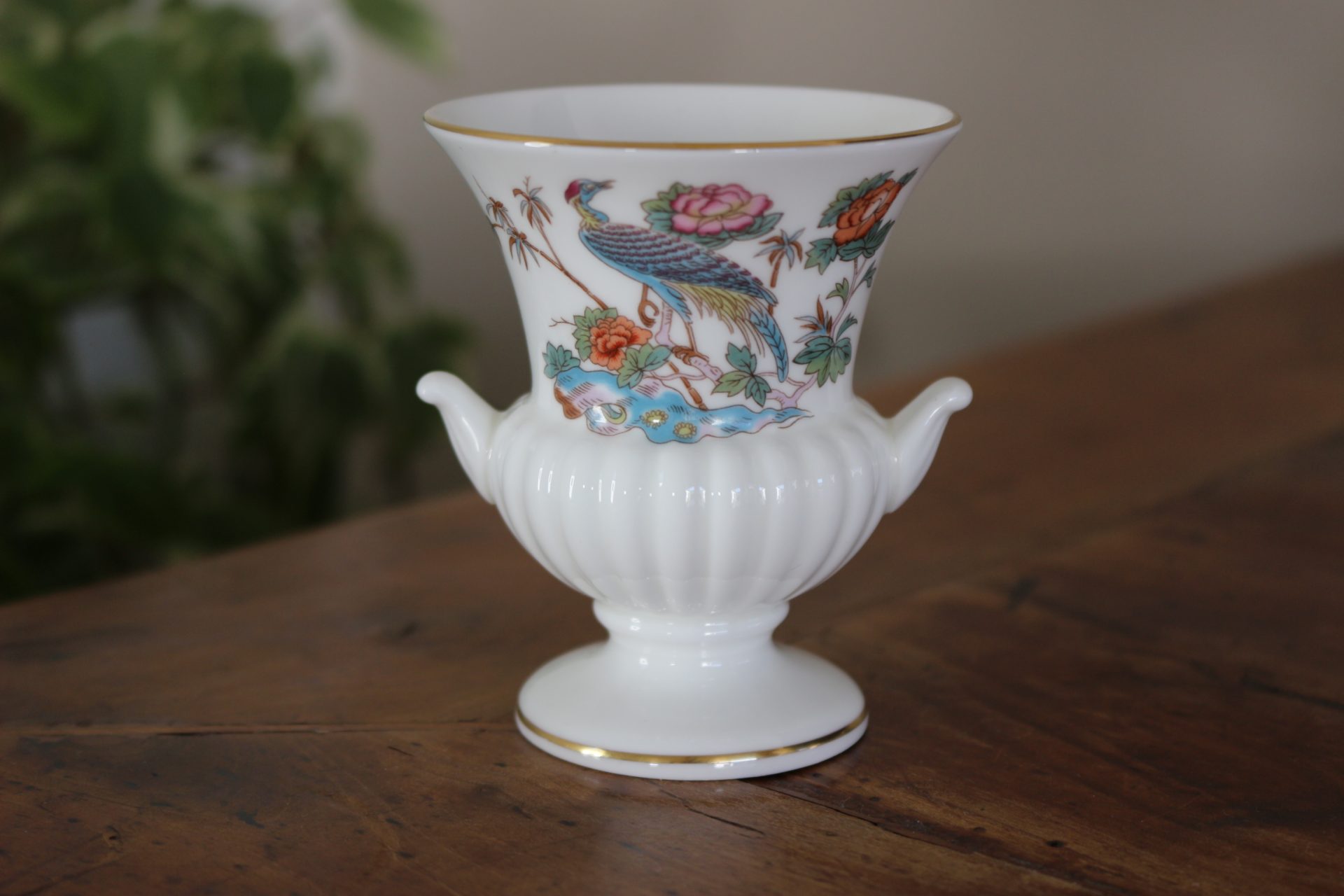 Charmante miniature en porcelaine pour ce vase de forme Médicis avec un décor de paon et fleurs