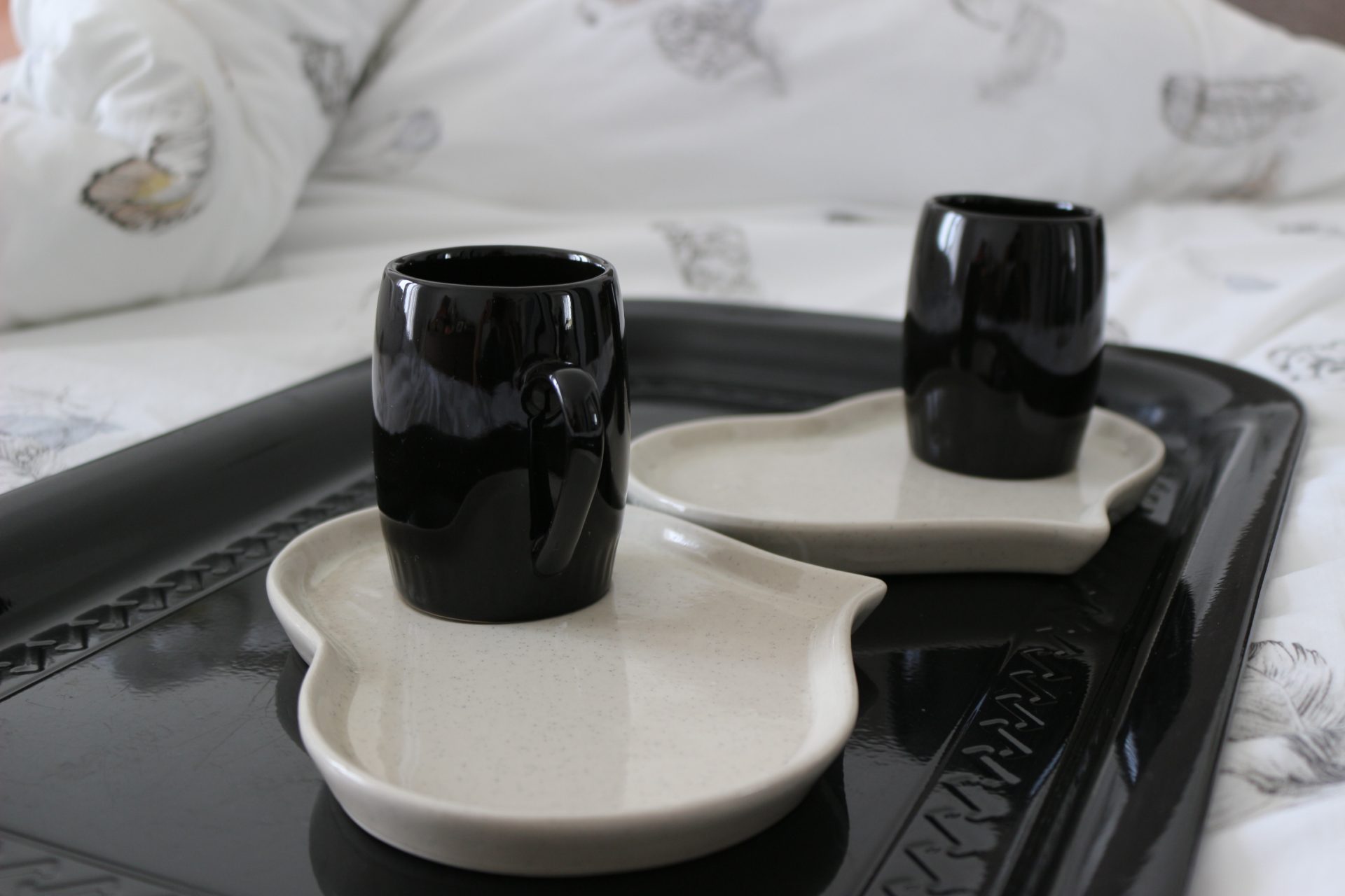 Duo de tasses noires et soucoupes beiges en forme de coeur